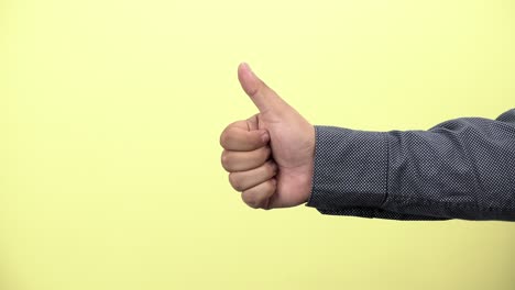 a-businessman-showing-thumbs-up-on-yellow-background