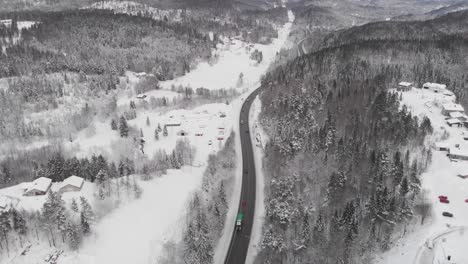 Aerial-View-Of-Winter-Road-In-The-Forest-Covered-With-Snow---drone-shot
