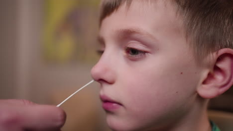 A-little-boy-gets-an-at-home-COVID-19-rapid-antigen-nasal-swab-test