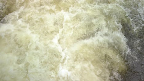 Close-up-view-of-destructive-water-current-of-the-flowing-Thetford-Little-river-in-Norfolk,-England-on-a-sunny-morning