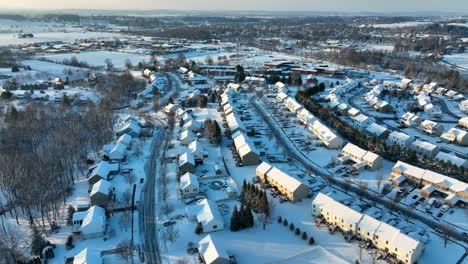 Aerial-of-homes-covered-in-winter-snow-at-sunrise