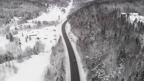 Narrow-Highway-Road-Across-White-Snow-Covered-Landscape-In-Norway---aerials-shot