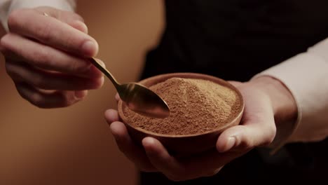 Hand-holding-Bowl-full-of-brown-sugar-with-spoon-Closeup-slowmotion-shot