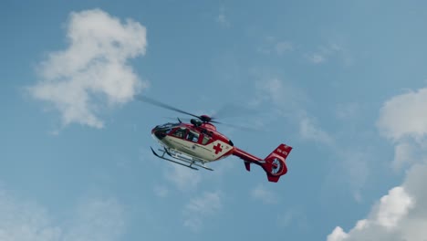 Helicóptero-De-Rescate-Aéreo-Médico-Que-Vuela-En-El-Cielo-Azul-Con-Nubes-Blancas---Día-Soleado-De-Slowotion