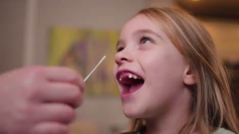 A-young-girl-laughs-her-way-through-a-COVID-19-nasal-swab-for-a-rapid-antigen-test