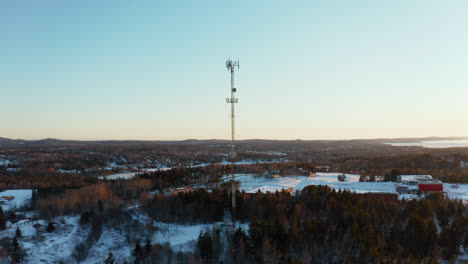 Scenic-winter-aerial-flying-around-a-cell-site-tower-at-sunset