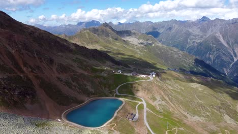 Luftaufnahmen-Von-Einem-Bergsee-In-Den-österreichischen-Alpen-An-Sonnigen-Sommertagen-Mit-Nur-Wenigen-Flauschigen-Wolken-Am-Himmel