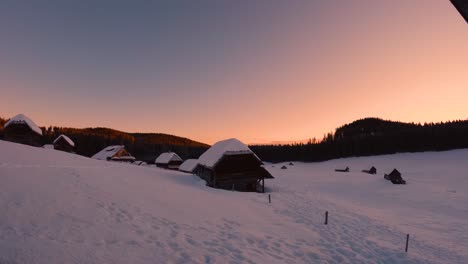 Zeitraffer-Aus-Einem-Bergdorf-Bei-Sonnenaufgang-Mit-Wunderschönen-Farben-Am-Himmel-Im-Winter-Mit-Schnee-Und-Schneebedeckter-Natur
