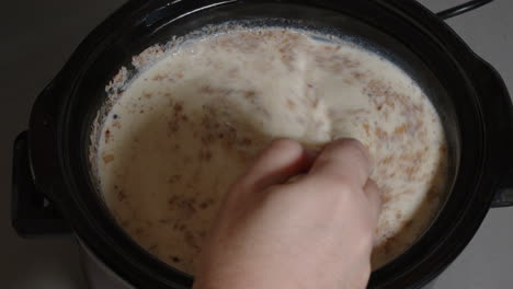 Stirring-rice-pudding-in-the-slow-cooker,-ms