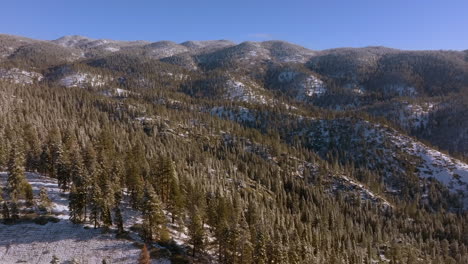 Beautiful-winter-landscape-in-the-mountains-of-Lake-Tahoe,-Nevada-with-a-pan-over-trees-and-hills-on-the-horizon