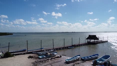 wooden-dock-and-fishing-boat-at-lake-blue-sky-and-chelem-yucatan-mexico