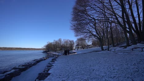 Niagara-on-the-lake-winter-walking-path-during-winter-covered-in-snow-and-ice-on-cold-day-with-bright-blue-mid-day-sky