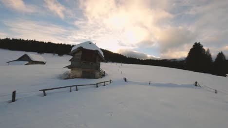 FPV-drone-shot-captured-in-Slovenia-in-Pokljuka-forest-with-surrounding-nature-and-mountains-at-golden-hour-at-sunset-with-fast-and-cinematic-movement-around-the-village-and-forest