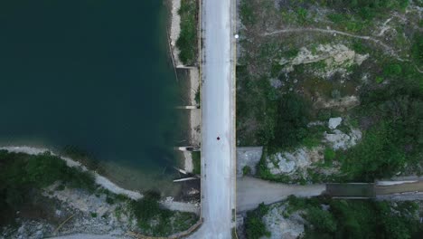 Drone-top-down-eye's-bird-view-of-crossing-bridge-road-in-nature-mountain-landscape-with-clear-lake-and-pine-tree-natural-Forest