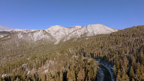 Aerial-of-mountains-and-forest-of-Douglas-Firs-trees-with-a-road-cutting-through-them