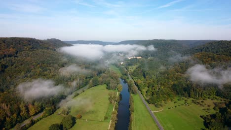 Drone-footage-from-the-border-of-Luxembourg-and-Germany,-a-river-flowing-between-the-two-countries,-while-clouds-are-moving-above-it