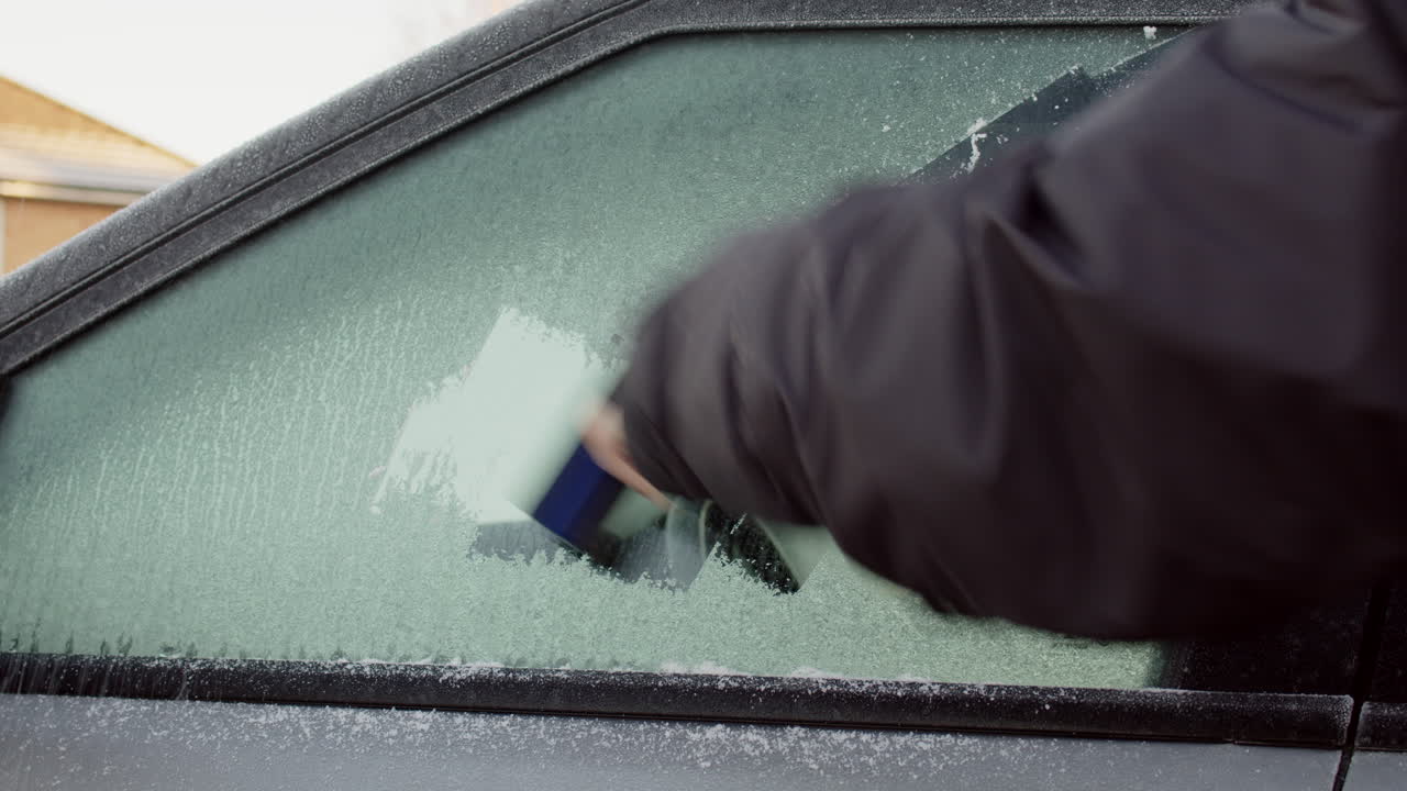Premium stock video - Scraping ice off car window