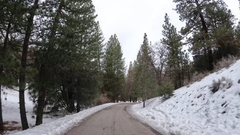Fahrt-Zu-Einem-Winterwunderland-In-Den-Bergen-Von-Tehachapi,-Kalifornien,-Entlang-Einer-Abgelegenen-Straße-Mit-Schnee-Auf-Dem-Boden---Rückansicht