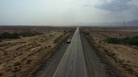 Aerial-Over-Along-Road-Through-Desert-Plains-In-Balochistan-With-Truck-Parked-On-Side