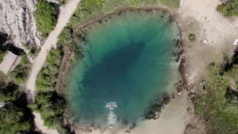 Cenital-drone-video-over-Lake-Cetina-with-people-walking-and-one-person-swimming