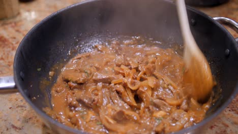 Stirring-Homemade-Sauteed-Beef-In-A-Wok-With-Wooden-Spoon