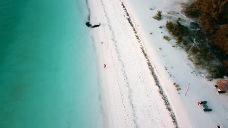 Smooth-tilt-up-reveal-fly-forwards-drone-shot-over-a-dream-beach