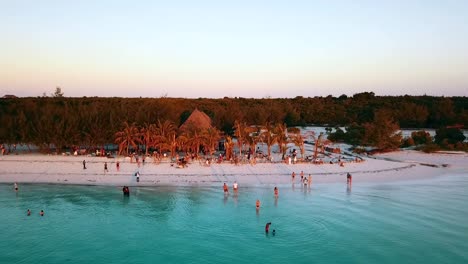 Calmer-panorama-curve-flight-drone-shot-at-golden-hour-sunset-beach-bar