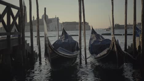 Gondola-swaying-at-the-port-in-the-morning-light,-Venice