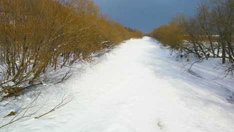 Pan-Up-View-Of-Frozen-Snow-Covered-River-In-Hokkaido