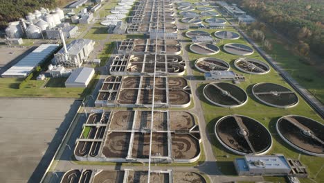 Aerial-establishing-shot-of-a-huge-biological-wastewater-treatment-plant-on-evening-flying-forward