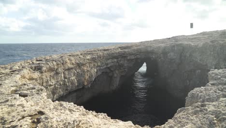 Cueva-De-La-Laguna-De-Coral-Con-Entrada-Visible-Al-Mar-En-Un-Día-Ventoso-En-Malta-En-Invierno