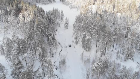 Aerial-View-Of-A-Car-On-Winter-Road-In-The-Forest---drone-shot