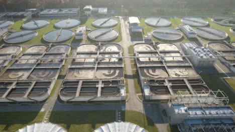 Aerial-trucking-shot-towards-the-sun-over-the-huge-wastewater-treatment-plant