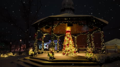Community-park-gazebo-and-decorated-Christmas-tree-at-night-during-snowstorm