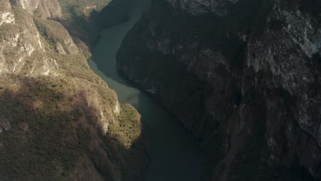 Aerial-tilt-up-shot-of-scenic-curvy-Grijalva-River-In-Sumidero-Canyon-during-sunny-day,Mexico