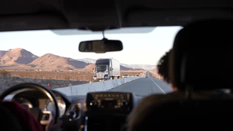 Conduciendo-Por-Una-Carretera-En-El-Desierto-De-Mojave-En-Una-Carretera-Dividida-Debido-A-La-Construcción---Vista-Desde-El-Asiento-Trasero-Con-Los-Ocupantes-Del-Asiento-Delantero-Visibles