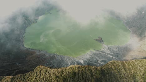 Toma-Aérea-De-Movimiento-Hacia-Atrás-De-Nubes-Blancas-Que-Soplan-A-Través-Del-Cráter-Y-El-Lago-Del-Volcán-El-Chichonal-En-Chiapas,-México-En-Un-Día-Nublado