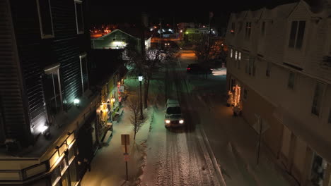 Truck-drives-on-snow-covered-street-at-night