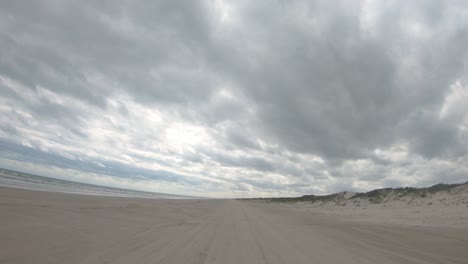 POV-thru-the-rear-window-of-vehicle-on-the-beach-on-North-Padre-Island-National-Seashore-near-Corpus-Christi-Texas-USA-on-a-cloudy-day-at-low-tide