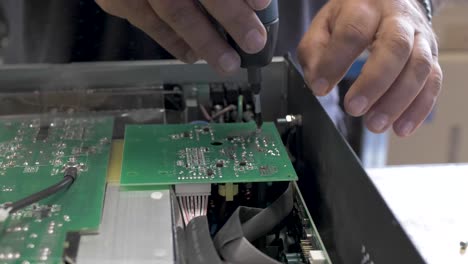 Technician-unscrewing-and-disassembling-a-solar-inverter-box-with-a-screwdriver,-Close-up-shot