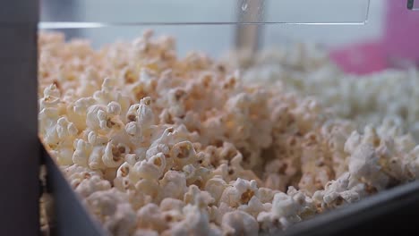 Piles-of-popcorn-in-display-case,-Shot-shot-with-dolls