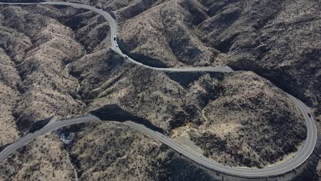 Winding-highway-74-through-desert-hilly-landscape-of-California,-aerial-drone-shot