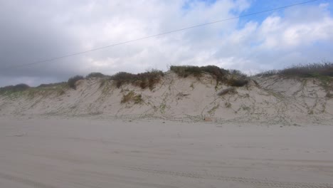 POV-while-driving-along-sand-dunes-in-Pardre-Balli-County-Park-in-Nueces-County-Park-on-North-Padre-Island-near-Corpus-Christi-Texas