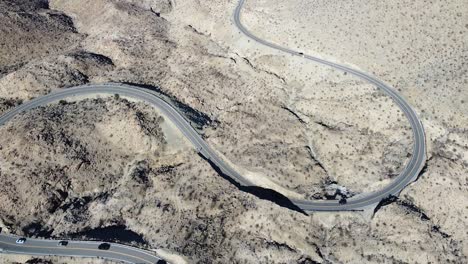 Loops-of-highway-74-in-California-desert-with-cars-driving,-aerial-drone-shot