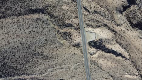 Empty-highway-road-with-concrete-stop-in-California-desert,-aerial-top-down-shot