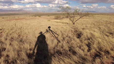 Funny-shadow-of-woman-photographer-on-ground-while-camera-on-tripod-shooting-photos