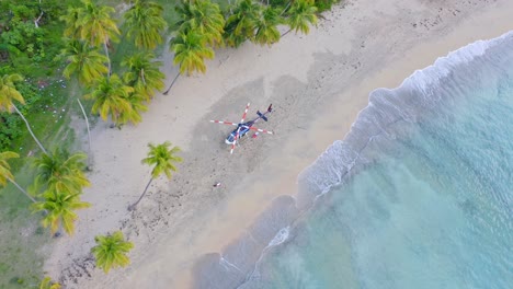 Aerial-top-down-shot-of-celebrity-with-private-helicopter-landing-on-sandy-beach-of-Playa-Esmeralda,Dominican-Republic