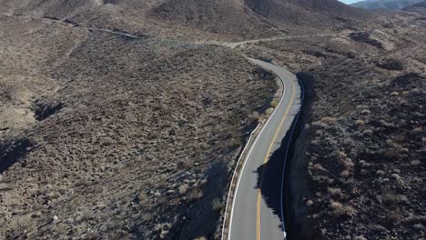 Black-car-driving-on-desert-road-in-California