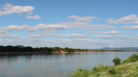 Río-Mekong-Que-Fluye-Con-Un-Hermoso-Cielo-Azul-Y-Un-Lapso-De-Tiempo-De-Nubes-Visto-Desde-El-Lado-De-Tailandia-De-La-Frontera-Entre-Tailandia-Y-Laos