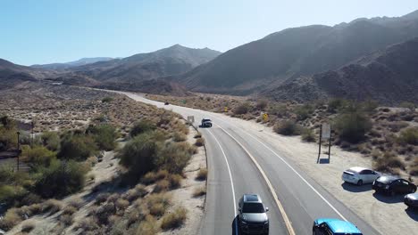 Cars-driving-on-desert-highway-in-California,-low-altitude-aerial-shot